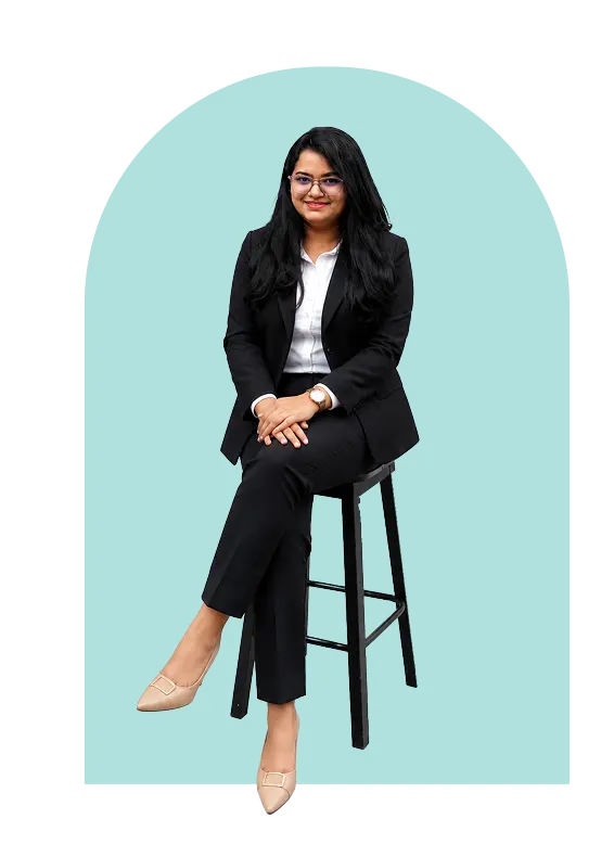 Fefin Areekkal Poulose (one woman) is sitting on a stool, and the background is blue.